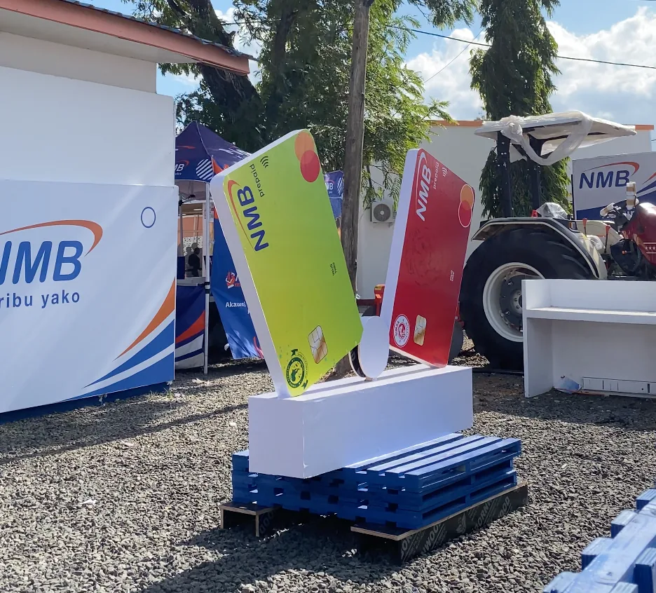 Oversized fabricated NMB prepaid card set pieces outside the pavilion at Saba Saba
