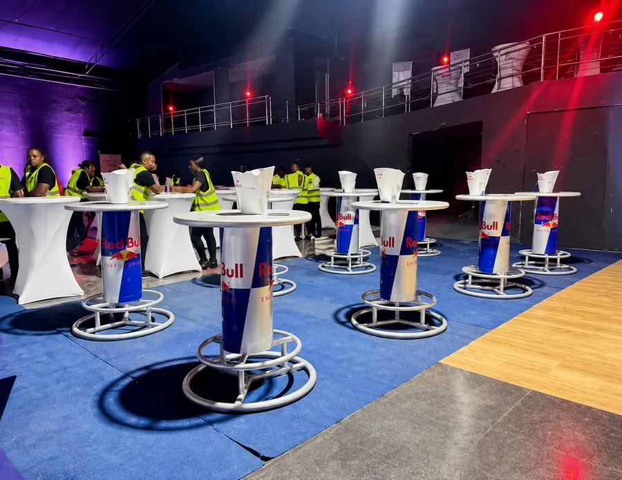 Red Bull branded cocktail tables set up inside an indoor venue activation