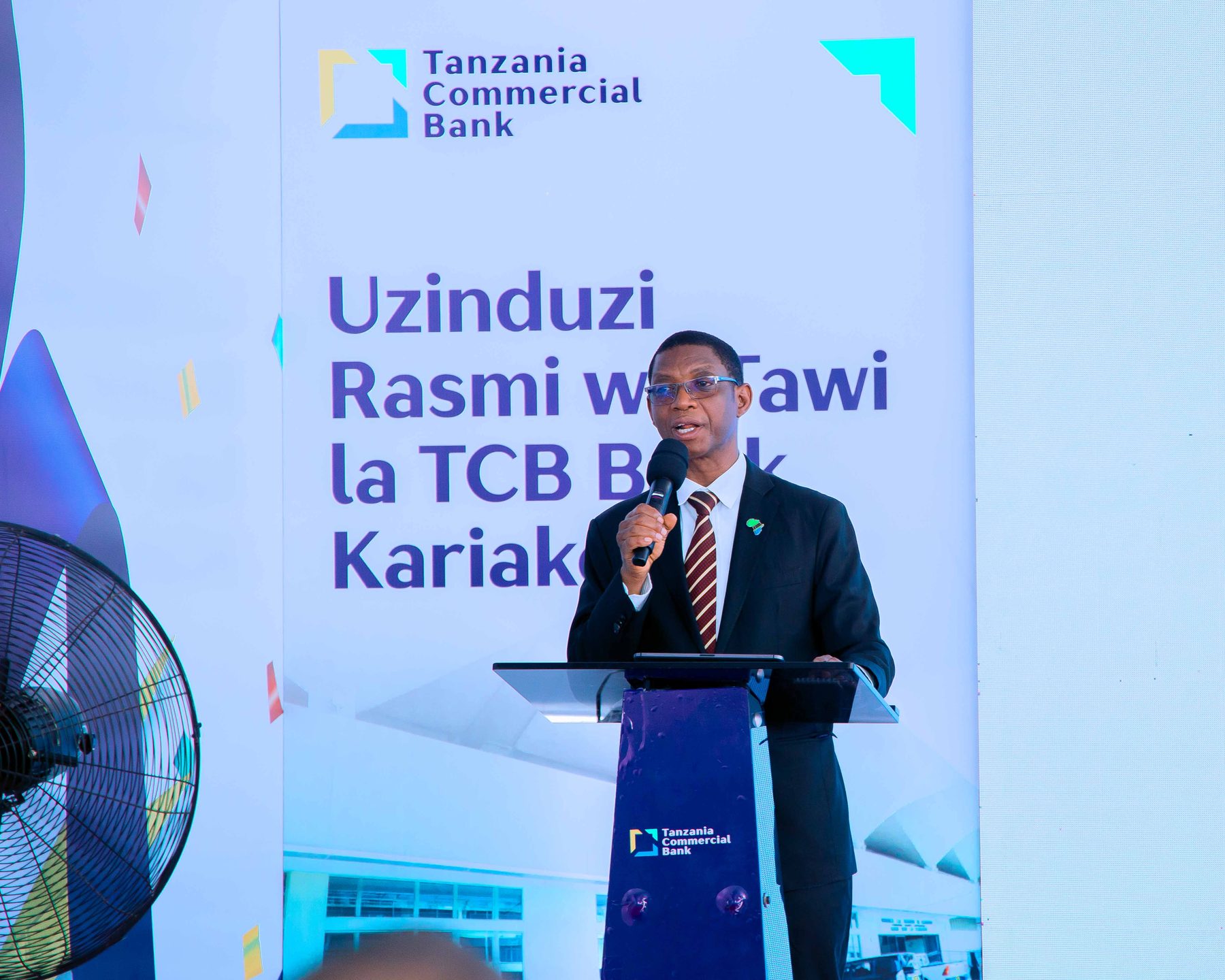 TCB executive addressing guests at the podium, Kariakoo branch launch