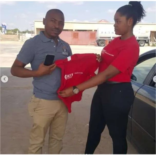 Oryx brand ambassador handing branded merchandise to a customer at a retail fuel station